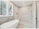 Bathroom with soaking tub, walk-in shower, and marble tile at 6052 Honey Hole Haven, Johns Island, SC 29455