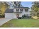 Two-story white house with a red door, attached garage, and manicured lawn at 1600 Windsor Ln, Moncks Corner, SC 29461