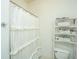 Clean bathroom with shower stall, white ruffled curtain, and shelving unit at 64 Radcliffe St, Charleston, SC 29403