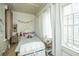 Small bedroom with twin bed, decorative storage chest, and window with curtains at 64 Radcliffe St, Charleston, SC 29403
