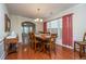 Formal dining room with hardwood floors, a large wooden table, and red curtains at 551 Rosings Dr, Summerville, SC 29486