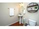 Clean bathroom with pedestal sink, decorative shelving, and wood flooring at 551 Rosings Dr, Summerville, SC 29486