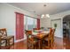 Bright dining room with hardwood floors, a large wooden table, and red curtains at 551 Rosings Dr, Summerville, SC 29486