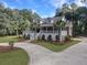 Brick home with a large wrap-around porch, palm trees, and a circular driveway at 102 Flud St, Summerville, SC 29483