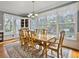 Sunlit dining room with hardwood floors, large windows, and a wooden table with seating for six at 102 Flud St, Summerville, SC 29483