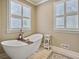 Relaxing bathroom with a large soaking tub, plantation shutters, and tiled floors at 102 Flud St, Summerville, SC 29483