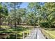 Wooden footbridge leading through a lush, wooded landscape at 4239 Tom Point Rd, Hollywood, SC 29449