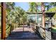 Wooden deck with metal railing, leading to a screened porch at 4239 Tom Point Rd, Hollywood, SC 29449