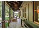 Long covered porch with wooden floors and metal railing; features a weight bench at 4239 Tom Point Rd, Hollywood, SC 29449