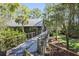 Elevated wooden walkway leading to a charming green house nestled in the woods at 4239 Tom Point Rd, Hollywood, SC 29449