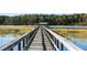 Long wooden dock leading to a waterfront boathouse at 4239 Tom Point Rd, Hollywood, SC 29449