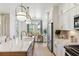 Open kitchen with white cabinets, large island, and stainless steel appliances at 297 Claret Cup Way, Charleston, SC 29414
