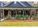 Covered front porch with teal rocking chairs and wooden posts at 112 Canewood Ln, Ridgeville, SC 29472