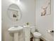 Stylish powder room with pedestal sink, toilet, and framed deer art at 112 Canewood Ln, Ridgeville, SC 29472