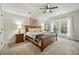 Bright bedroom with a wooden bed frame and large windows offering natural light at 112 Canewood Ln, Ridgeville, SC 29472