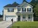 Two story home with a yellow exterior, black shutters, and a neatly landscaped yard at 127 Meadow Wood Rd, Summerville, SC 29486