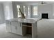 Island kitchen features white shaker cabinets, quartz countertops, and farmhouse sink at 357 Wappoo Trace Ln, Summerville, SC 29486