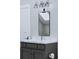 Gray vanity with marble countertop, rectangular mirror, and modern light fixture at 5209 Seewee Rd, Awendaw, SC 29429