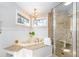 Luxurious bathroom with corner jacuzzi tub, walk-in shower, and elegant chandelier at 1328 Southlake Dr, Mount Pleasant, SC 29464
