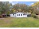 White house with a large grassy backyard, and mature trees at 2503 S Hwy 17A, Summerville, SC 29483