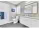 Clean bathroom with white vanity, gray tile floors, and a window for natural light at 318 Simmons Ave, Summerville, SC 29483