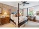 Spacious bedroom with a four-poster bed, exposed brick wall, and ceiling fan at 40 1/2 State St, Charleston, SC 29401