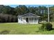 Gray house with white trim and porch, nestled in a wooded setting at 8266 N Highway 17, McClellanville, SC 29458