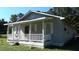 Quaint gray home with white shutters, a covered porch, and a spacious yard at 8266 N Highway 17, McClellanville, SC 29458