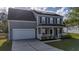 Two story gray house with white garage door and front porch at 417 Crystal Oaks Ln, Moncks Corner, SC 29461