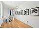 Light and airy hallway with hardwood floors and modern artwork at 64 Grand Pavilion Blvd, Isle of Palms, SC 29451