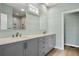 Double vanity bathroom with gray cabinets and large mirrors at 1008 Mariners Cay Dr, Folly Beach, SC 29439