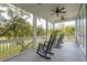 Serene screened porch with rocking chairs and views of a tranquil backyard at 5250 Timber Race Crse, Hollywood, SC 29449