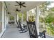 Peaceful screened porch featuring rocking chairs and views of the surrounding landscape at 5250 Timber Race Crse, Hollywood, SC 29449