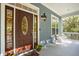 Front porch with a rich wooden door, white chairs, and colorful flowers at 5250 Timber Race Crse, Hollywood, SC 29449