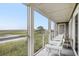 Enjoy marsh views from this screened porch with comfy seating at 93 Mariners Cay Drive, Folly Beach, SC 29439