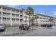 Multi-story building with ample parking and palm trees at 93 Mariners Cay Drive, Folly Beach, SC 29439