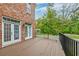 Back deck with wood flooring, brick house, and fenced backyard at 106 Aviary Ct, Summerville, SC 29483