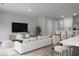 Spacious living room with large TV, white couch and dining area at 171 Rosefield Ct, Summerville, SC 29485