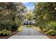A charming house is showcased with a long driveway leading to it, surrounded by lush greenery at 4028 Gnarled Oaks Ln, Johns Island, SC 29455