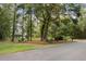 Attractive home nestled amongst lush trees, showcasing a manicured lawn and a long driveway at 4028 Gnarled Oaks Ln, Johns Island, SC 29455