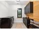Laundry room with dark cabinetry, wood-paneled walls, and a built-in bench at 4028 Gnarled Oaks Ln, Johns Island, SC 29455