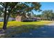 Brick ranch home with front porch and large yard, tree in foreground at 1802 Wood Duck Rd, Moncks Corner, SC 29461