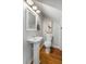 Small half bathroom with pedestal sink, toilet, and wood floor at 1665 A Marsh Harbor Ln, Mount Pleasant, SC 29464