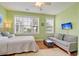 Bedroom with light green walls, queen bed, and gray sofa at 204 Michigan Ave # D2, Folly Beach, SC 29439