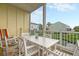 Screened porch with white table and chairs, rocking chair, water view at 204 Michigan Ave # D2, Folly Beach, SC 29439