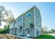 Side view of three-story townhomes showcasing modern design and landscaping at 211 Cache Ct # 6, Charleston, SC 29414
