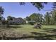 Spacious backyard with a large grassy area, mature trees, and a home with a fenced-in pool at 443 Lazy Hill Rd, Moncks Corner, SC 29461