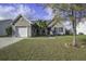 Tan colored one-story house with a two-car garage and well-maintained lawn at 109 Dovetail Cir, Summerville, SC 29483