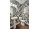 Stylish powder room with pedestal sink, toilet, and tropical-themed wallpaper at 1627 Siloh Drive Dr # 481, Mount Pleasant, SC 29466