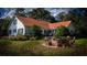 White farmhouse with a red metal roof and a backyard patio at 0 Tuten Road, Round O, SC 29474